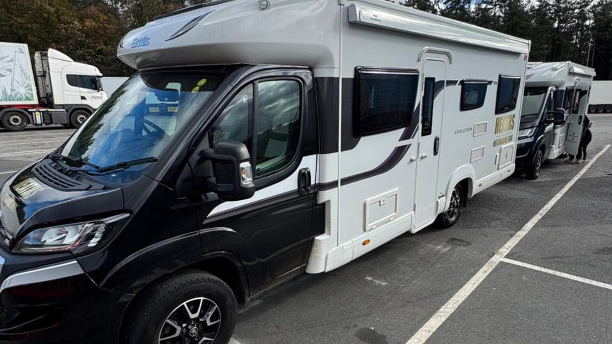 Two Elddis motorhomes parked side by side in a car park ready for collection
